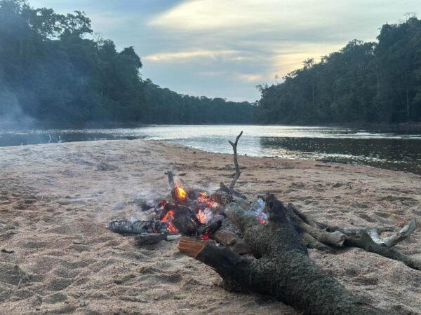Camp fire on a remote canoe expedition in the amazon rainforest
